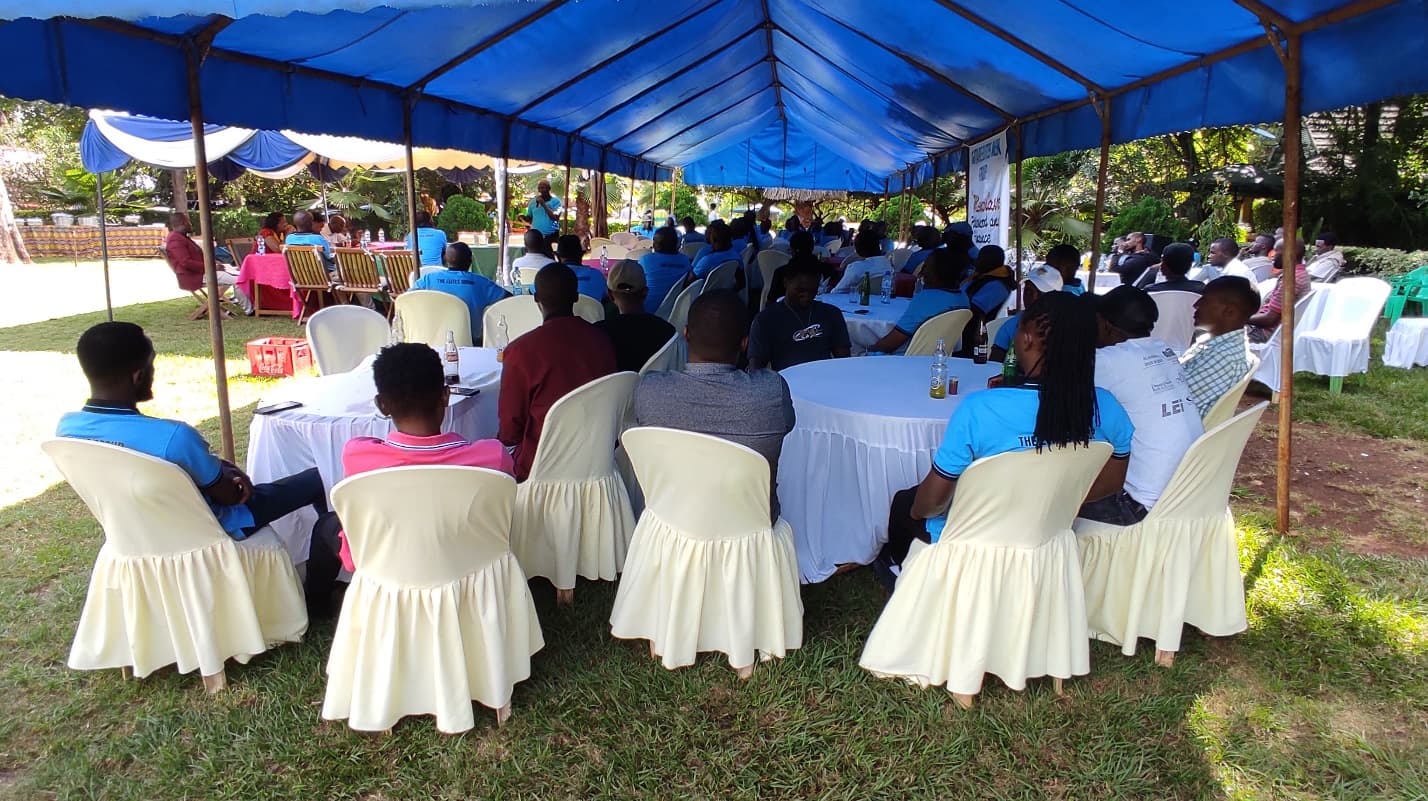 Active SACCO members attend Men’s Cave seminar for mentorship and networking under a vibrant outdoor setup.